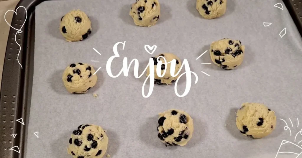 Placing scoop of blueberry cookies mixture on tray for baking